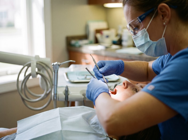 A hygienist cleaning a patient's teeth